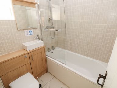 A bathroom with a bathtub, sink, mirror, and toilet at Carthouse Cottage Clarbeston Road