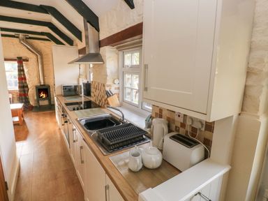 A kitchen with a stove, sink, and microwave at Knap Cottage in Clarbeston Road