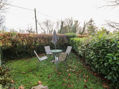 A garden with a table and chairs at Knap Cottage in Clarbeston Road