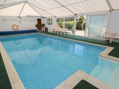 A swimming pool with chairs and a lifebuoy at Knap Cottage in Clarbeston Road