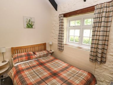 A bedroom with a bed and window at Corner Cottage in Clarbeston Road