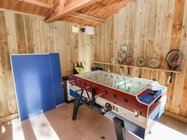 A game room with a foosball table and rackets on the wall at Corner Cottage in Clarbeston Road
