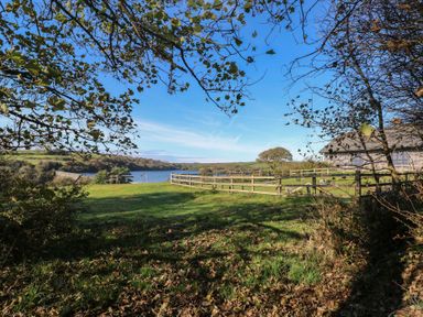 A landscape view with water and a fence at Stable Cottage in Clarbeston Road