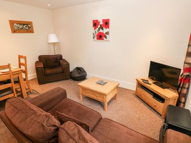 A living room with a sofa and coffee table at Swallows Cottage in Clarbeston Road
