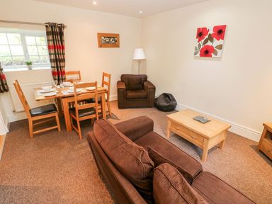 A living room with a table and chairs at Swallows Cottage in Clarbeston Road