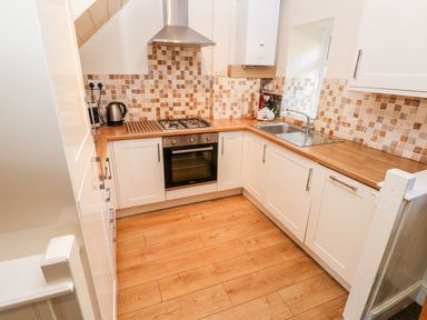 A kitchen with stove and sink at Swallows Cottage in Clarbeston Road