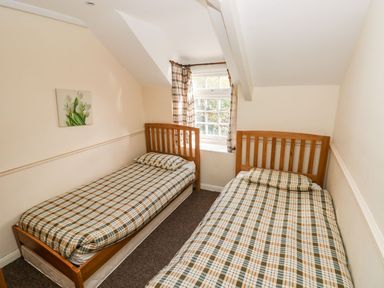 A bedroom with two beds and a window at Swallows Cottage in Clarbeston Road