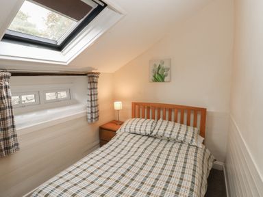 A bedroom with a bed and a lamp at Shippen Cottage in Clarbeston Road