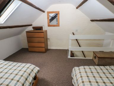 A bedroom with beds and a dresser at Shippen Cottage in Clarbeston Road