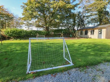 A garden with a soccer goal and a swing set at Shippen Cottage in Clarbeston Road