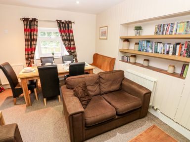 A dining room with a table and chairs at Lake Cottage in Clarbeston Road