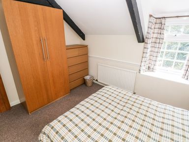 A bedroom with a bed and furniture at Lake Cottage in Clarbeston Road