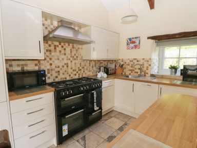 A kitchen with cabinets and appliances at Granary Cottage in Clarbeston Road