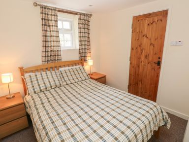 A bedroom with a bed and nightstands at Granary Cottage in Clarbeston Road