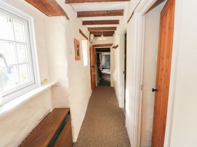 A hallway with a window and doors at Granary Cottage in Clarbeston Road