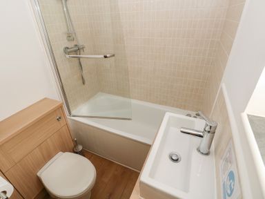 A bathroom with a shower, bathtub, sink, and toilet at Granary Cottage in Clarbeston Road