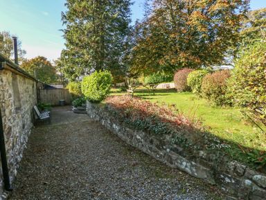 A garden with benches and a picnic table at Granary Cottage in Clarbeston Road
