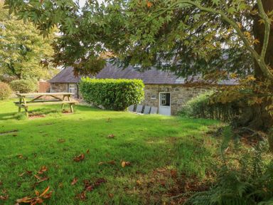 A garden with a picnic table and chairs at Granary Cottage in Clarbeston Road