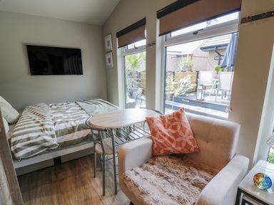 A bedroom with a bed and a table at Cabin At The Brig Annan