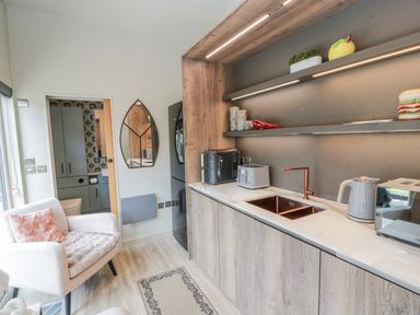 A kitchen with cabinets, sink, and appliances at Cabin At The Brig Annan