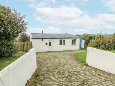 A cottage with a driveway in front at Harbour Lights in Holyhead