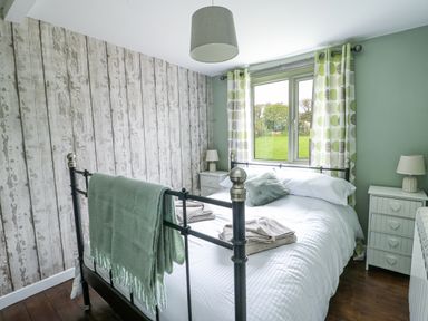 A bedroom with a bed and nightstands at Harbour Lights in Holyhead