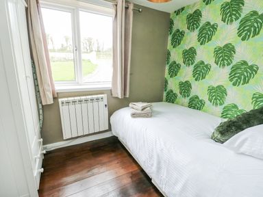 A bedroom with a bed and towels at Harbour Lights in Holyhead