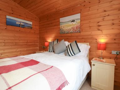 A bedroom with a bed and nightstand at Ocean Terrace 28 Ilfracombe