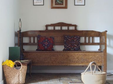 An entryway with a bench and cushions at The Old Post Box in 