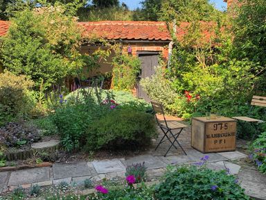A garden with plants and seating at The Old Post Box 