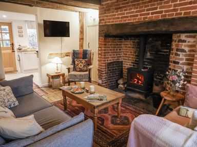 A living room with a sofa and fireplace at The Old Post Box in Halesworth