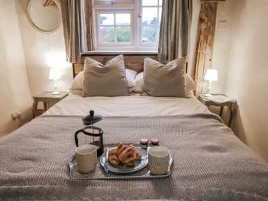 A bedroom with a bed and breakfast tray at The Old Post Box in Halesworth