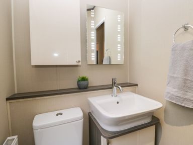 A bathroom with a sink and a mirror at Feather Hill Lodge in Windermere