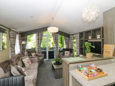 A living room with sofas and a coffee table at Feather Hill Lodge White Cross Bay near Troutbeck Bridge