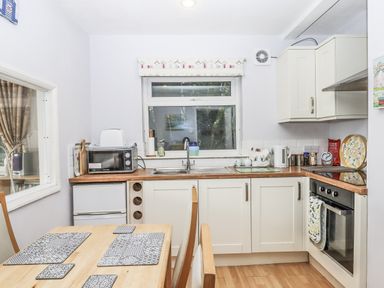 A kitchen with a table and chairs at Mayflower View in Dawlish