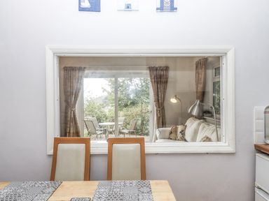 A dining room with a view of a living area at Mayflower View in Dawlish