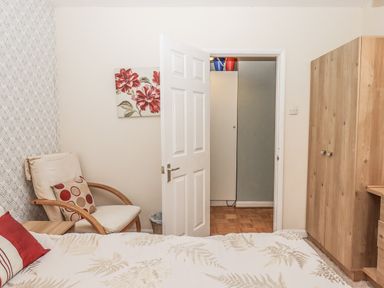 A bedroom with a bed and chair at Mayflower View in Dawlish