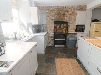 A kitchen with various appliances and cabinets at Pedn Brose near Mousehole