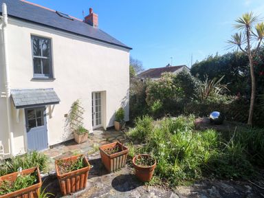 A garden with planters and a house at Pedn Brose Near Mousehole