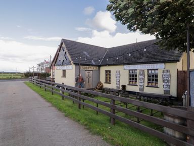 A building with signs and tables outside at Rusty Barn in Limavady