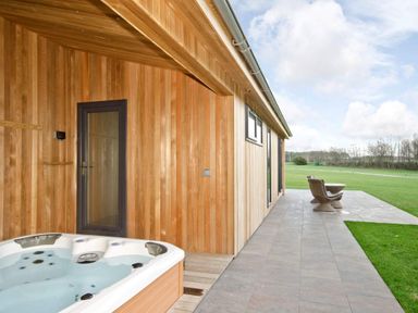 An outdoor area with a hot tub and seating at Brayton in Aspatria