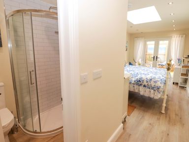 A bathroom with a shower and a bedroom with a bed at Sea Folly