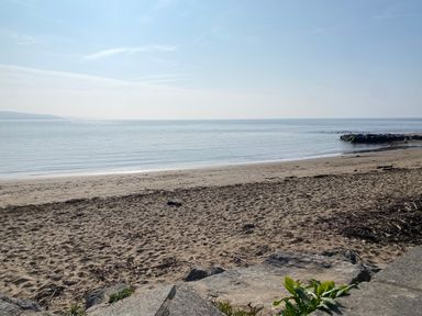 A beach with sand and water at Sea Folly in Porthcawl