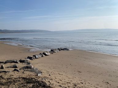 A beach with rocks along the shoreline at Sea Folly in Porthcawl