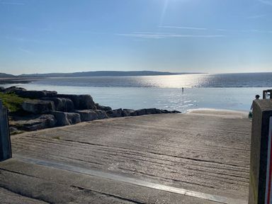 A beach scene with water and rocks at Sea Folly in Porthcawl