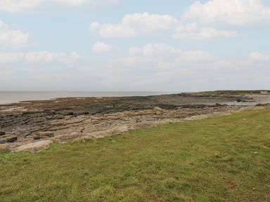 A coastal view with rocks and grass at Sea Folly in Porthcawl