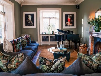 A living room with a piano and artwork at St Anne's Manor in Torquay