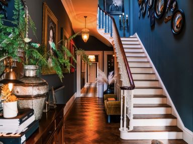 A hallway with a staircase and framed pictures at St Anne's Manor in Torquay