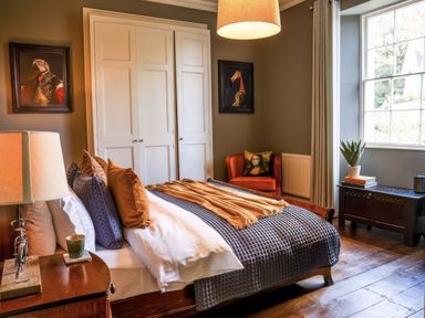 A bedroom with a bed and a chair at St Anne's Manor in Torquay