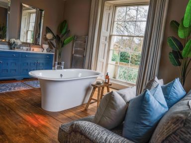 A bathroom with a bathtub and a cabinet at St Anne's Manor in Torquay